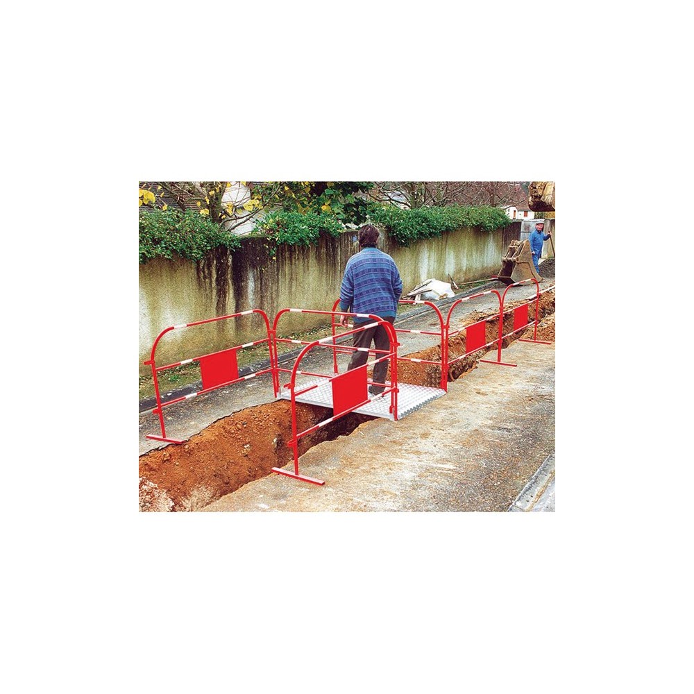 Photo de mise ne situation des barrières pour travaux temporaires disposée autour d'un trottoir en travaux.